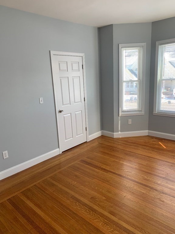 243 Bruce Street Lawrence, MA 01841 - Photo 15 of 16 a view of an empty room with wooden floor and window