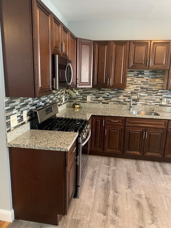 243 Bruce Street Lawrence, MA 01841 - Photo 8 of 16 a kitchen with kitchen island granite countertop a sink stove and cabinets
