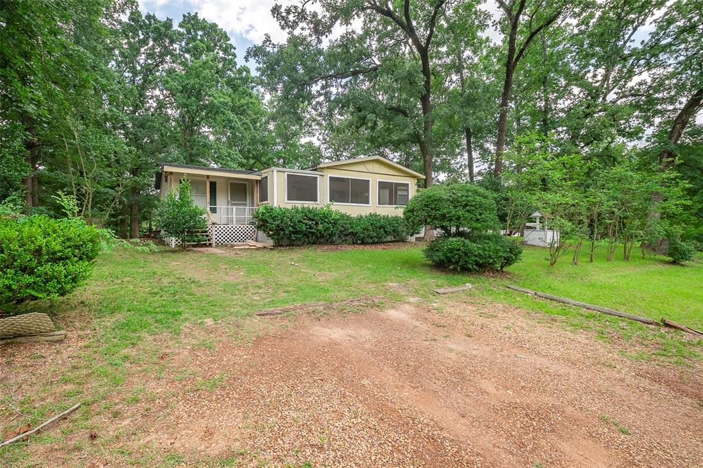 a view of a yard in front of a house with large trees