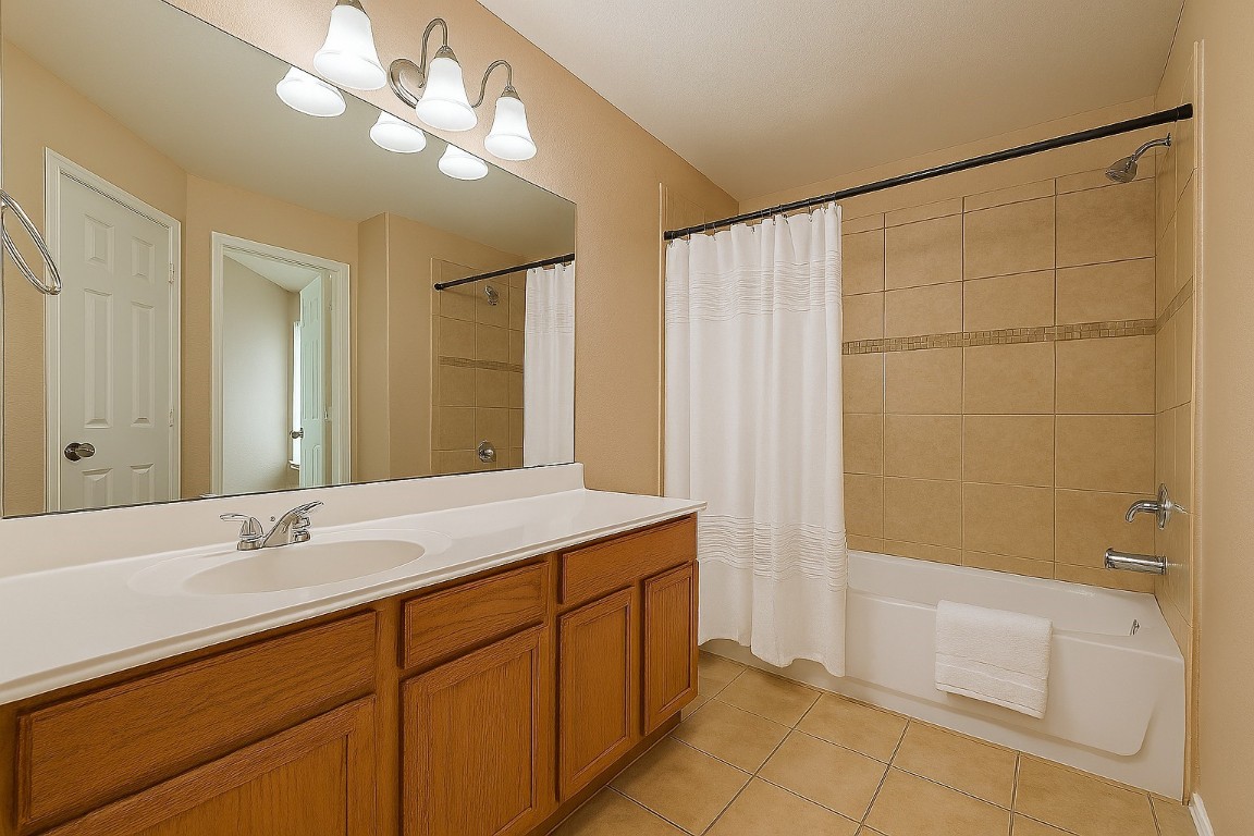 3611 Apache Meadows Drive Baytown, TX 77521 - Photo 10 of 12 a bathroom with a double vanity sink a large mirror and a bathtub