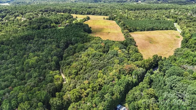 an aerial view of a house with a yard and lake view