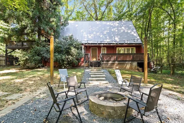 a view of a patio with table and chairs potted plants and large tree