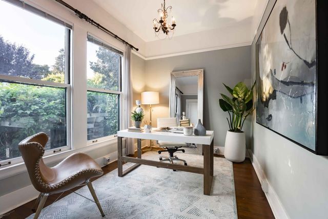 a view of a workspace with furniture and a window