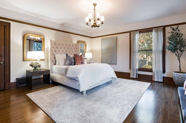 a spacious bedroom with a large bed and a chandelier