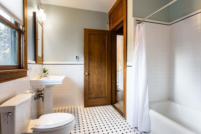 a bathroom with a sink a toilet a mirror and shower