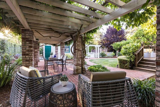 a view of a patio with a dining table and chairs with a barbeque grill and a fireplace