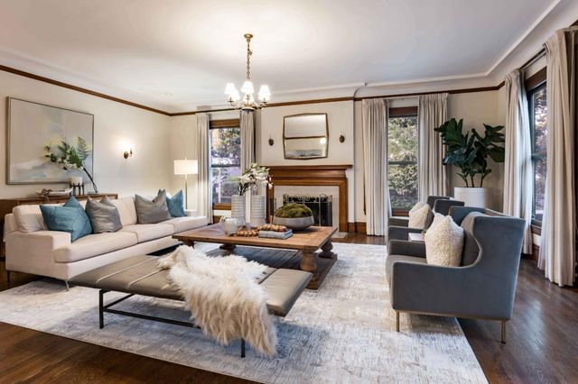 a living room with furniture fireplace and a large window