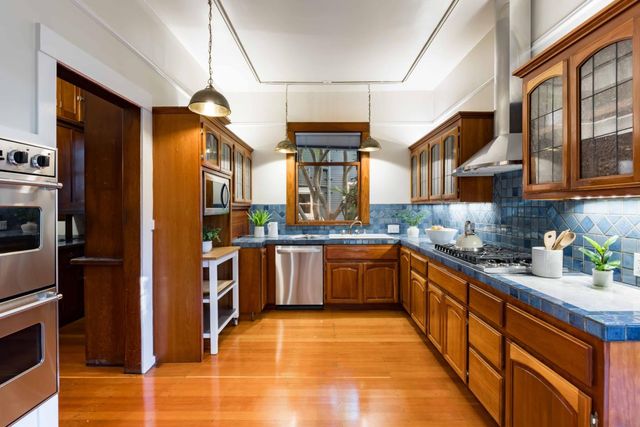 a large kitchen with stainless steel appliances granite countertop a refrigerator and a stove top oven
