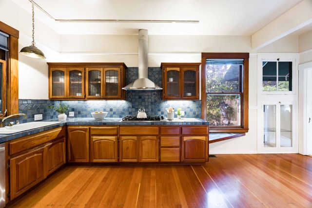 a kitchen with stainless steel appliances granite countertop wooden floors and sink