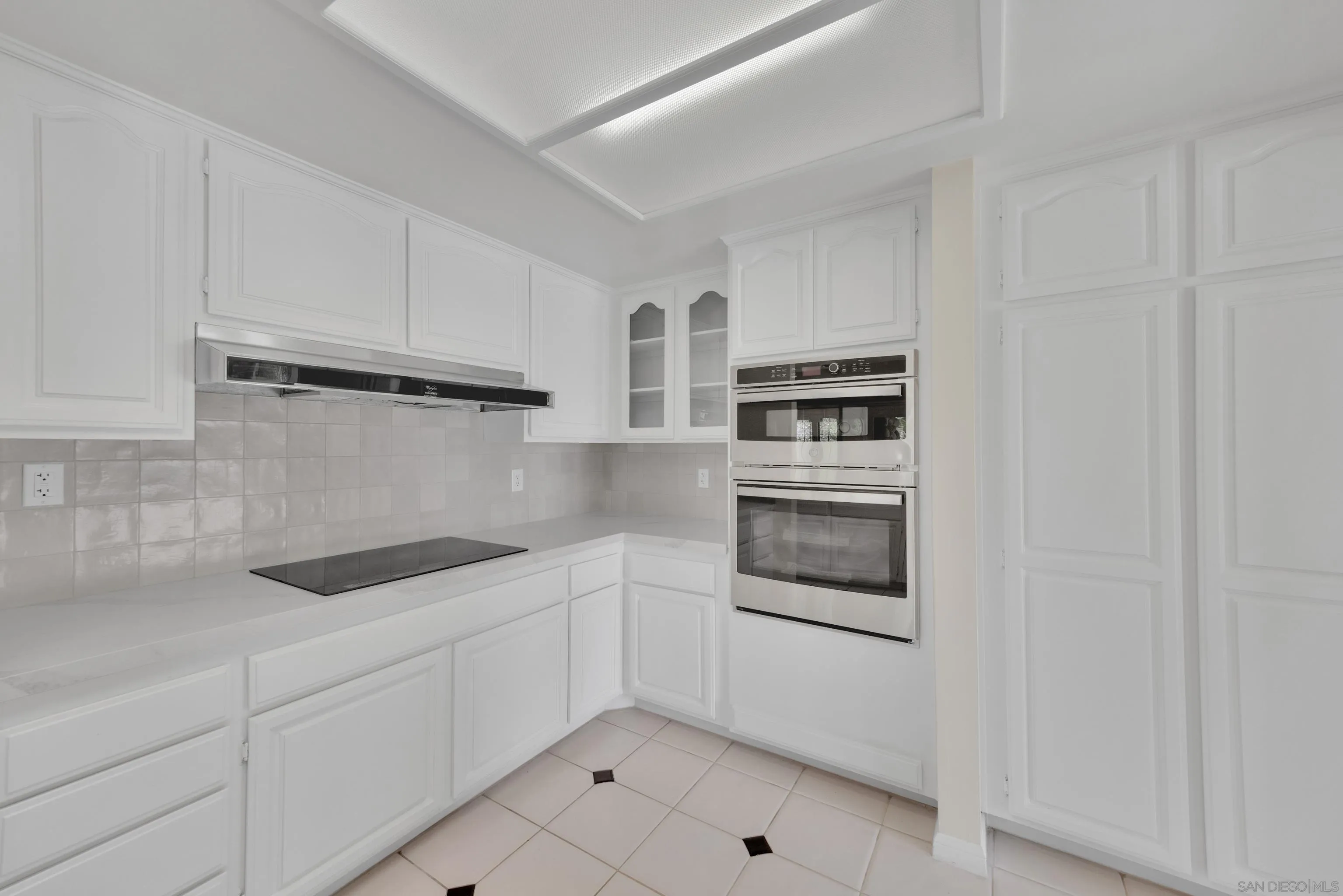 15235 Crestview Court Poway, CA 92064 - Photo 23 of 75 a kitchen with white cabinets and stainless steel appliances