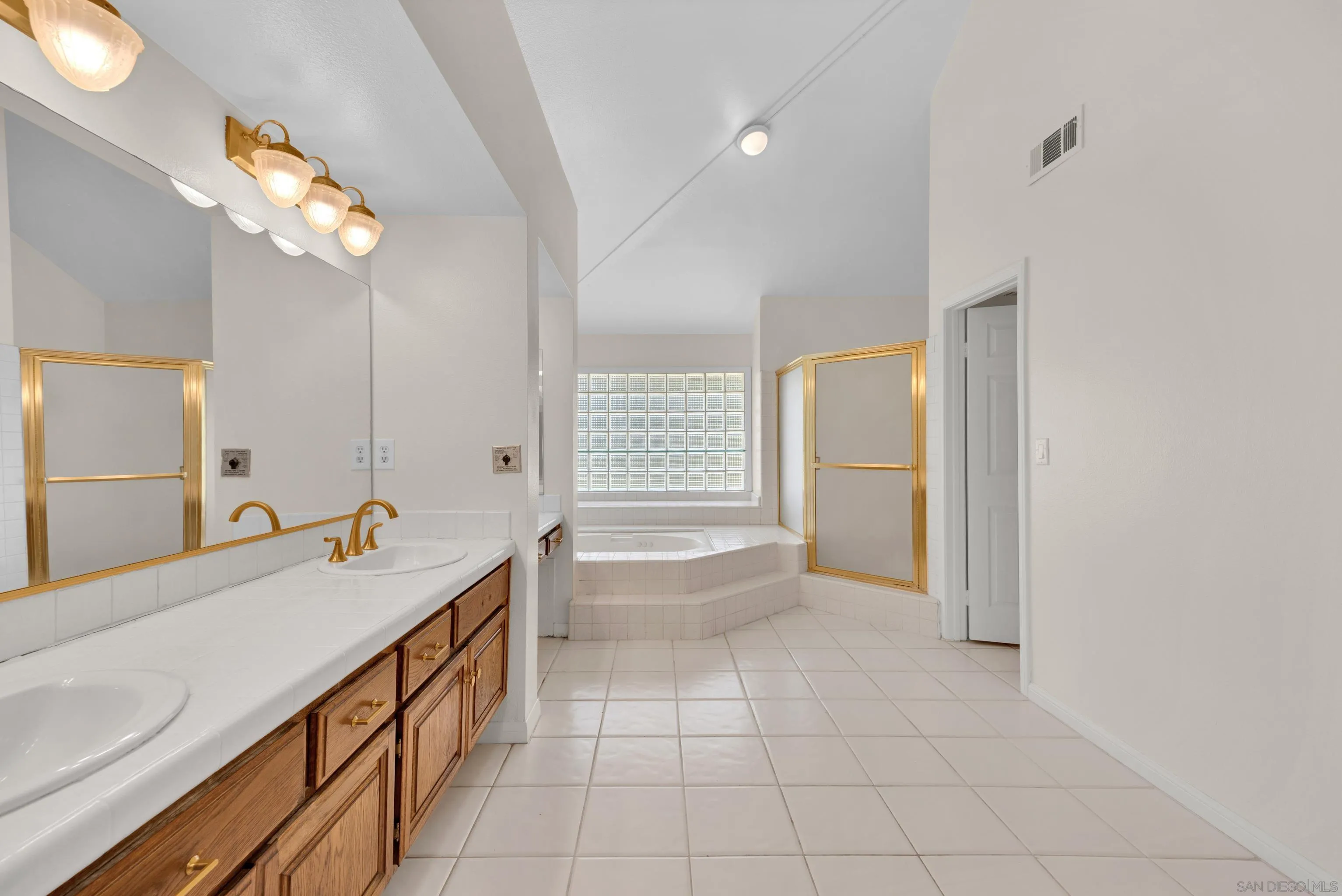 15235 Crestview Court Poway, CA 92064 - Photo 31 of 75 a bathroom with a sink a mirror and a bathtub