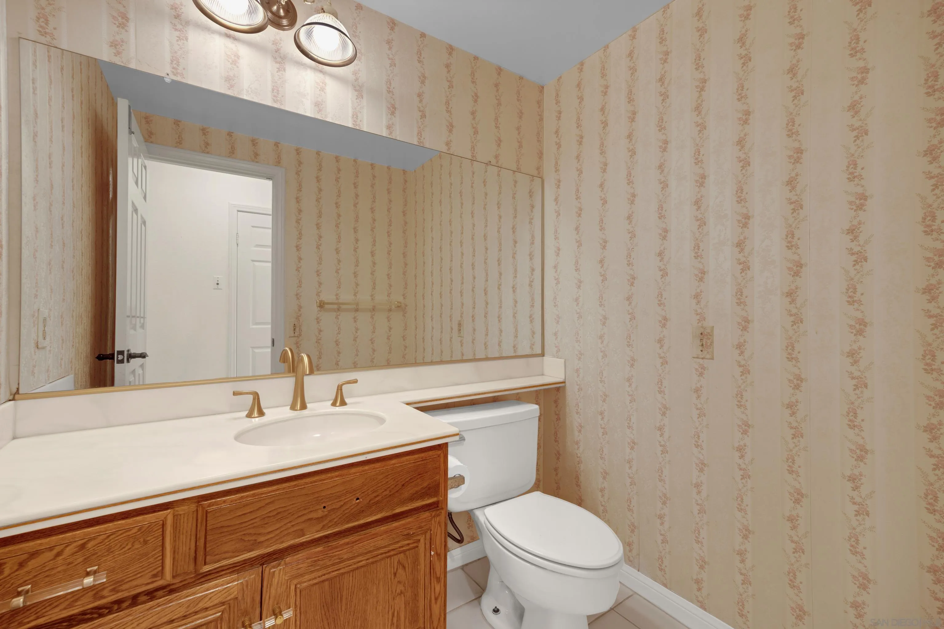 15235 Crestview Court Poway, CA 92064 - Photo 47 of 75 a bathroom with a granite countertop sink a toilet and a mirror