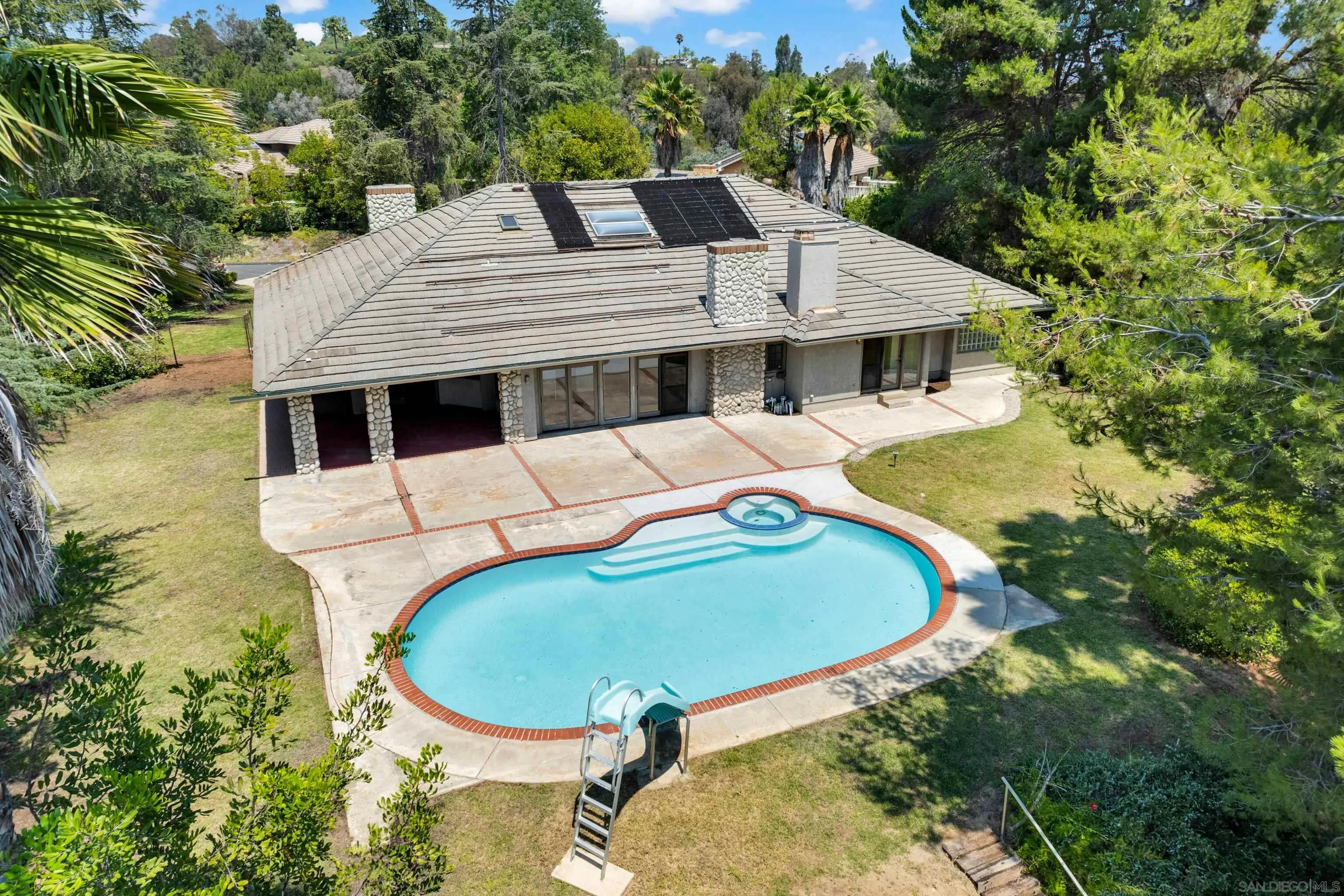 15235 Crestview Court Poway, CA 92064 - Photo 62 of 75 a roof deck with table and chairs under an umbrella with large trees