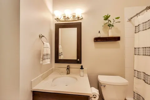 a bathroom with a toilet sink and mirror
