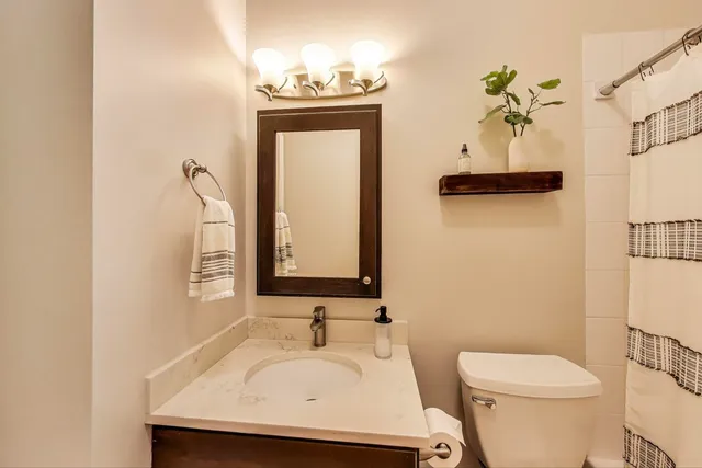 a bathroom with a toilet sink and mirror