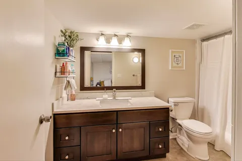 a bathroom with a sink vanity mirror and toilet