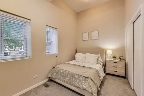 a bedroom with a bed and two windows