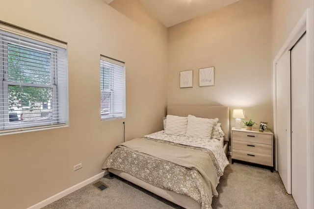 a bedroom with a bed and two windows