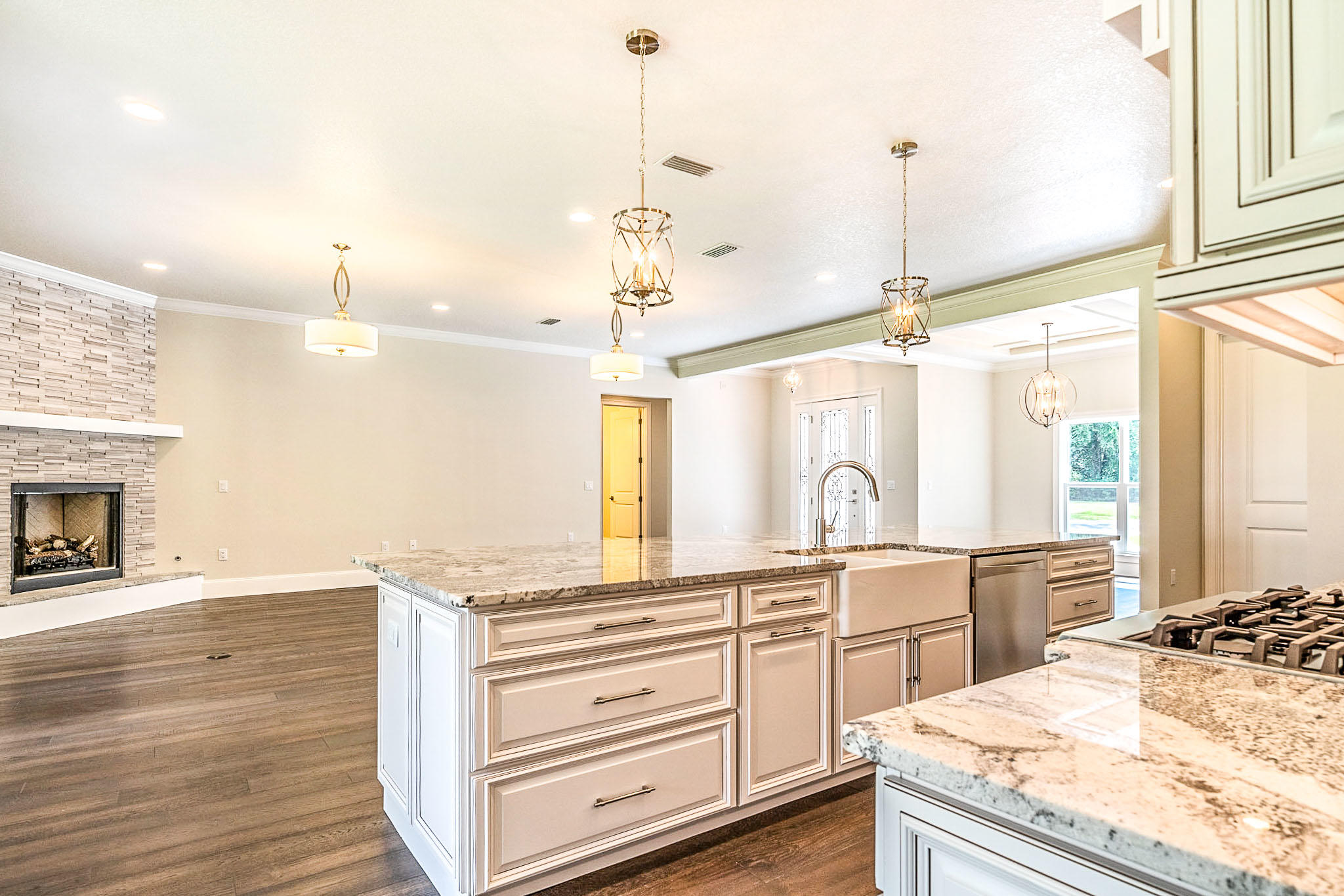 4809 Grove Street Crestview, FL 32539 - Photo 11 of 28 a view of a kitchen with kitchen island a sink wooden floor and a living room