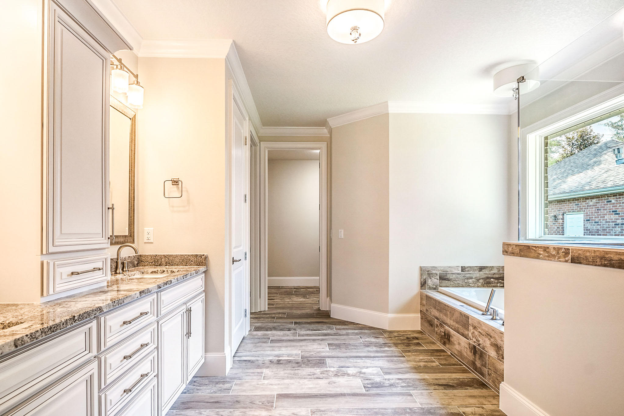 4809 Grove Street Crestview, FL 32539 - Photo 17 of 28 a spacious bathroom with a granite countertop sink a mirror and a bathtub