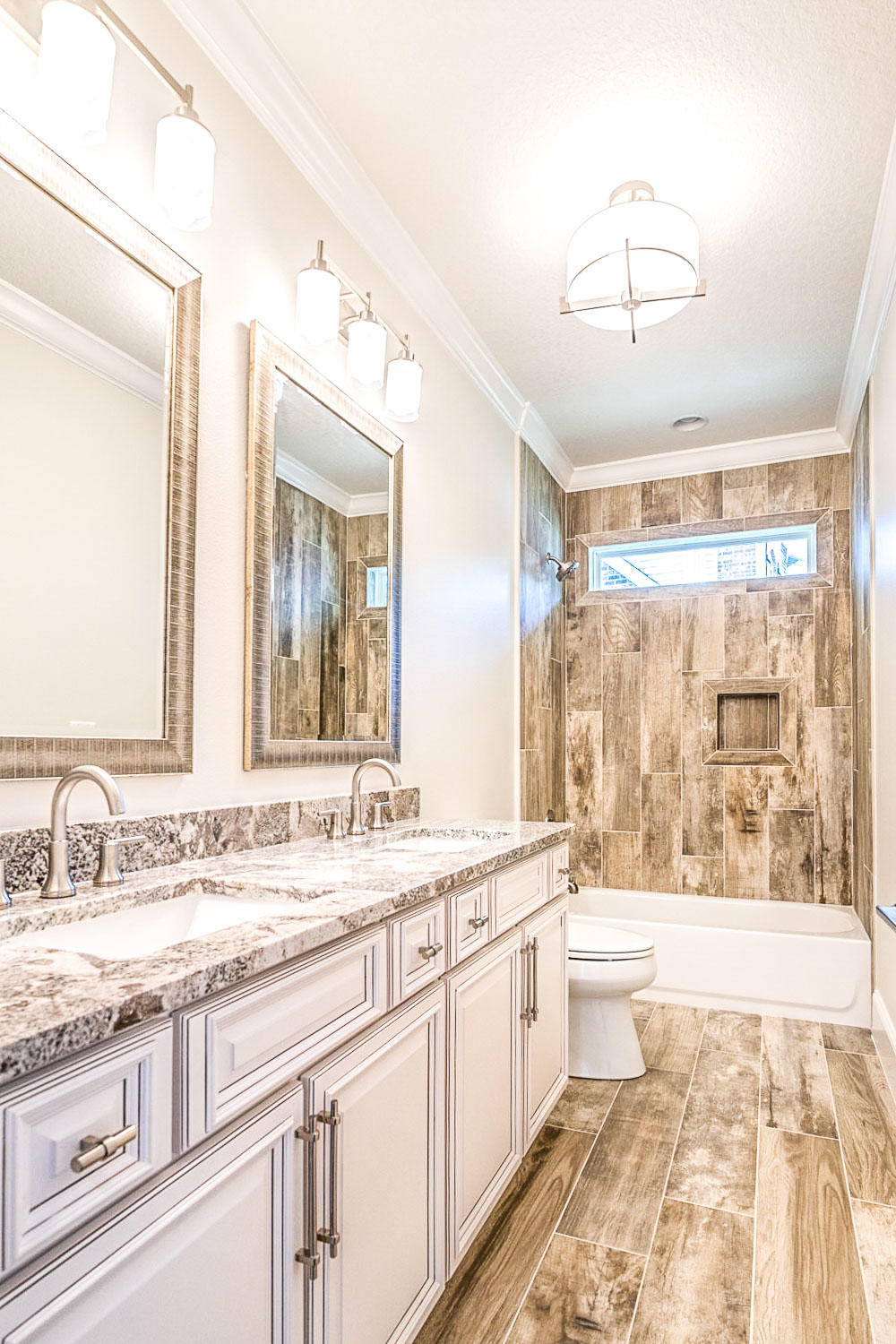 4809 Grove Street Crestview, FL 32539 - Photo 28 of 28 a bathroom with a granite countertop sink a large mirror a bathtub and next to a window