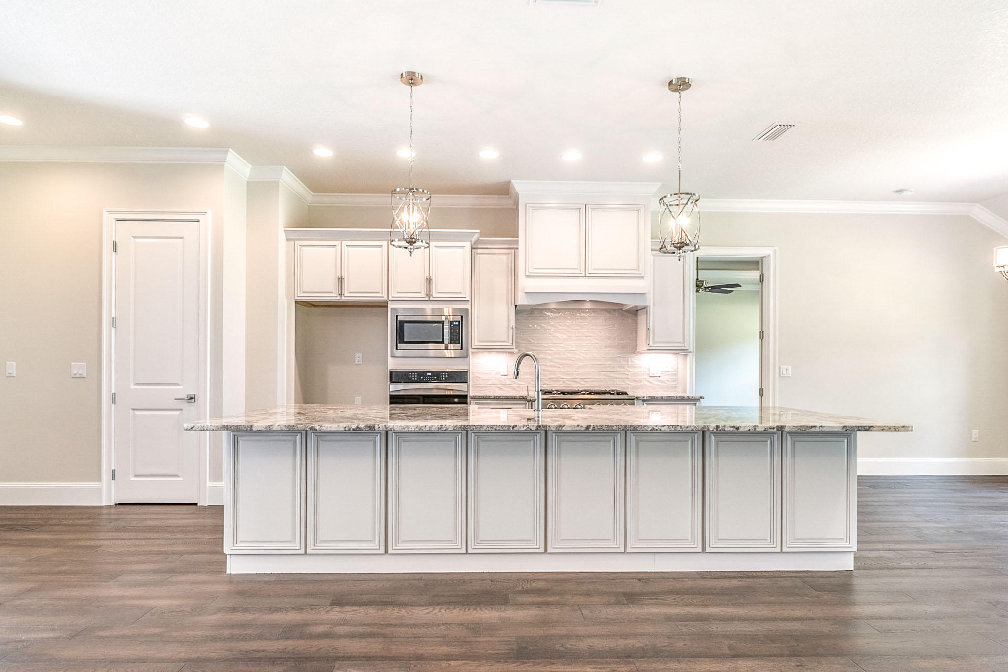 4809 Grove Street Crestview, FL 32539 - Photo 3 of 28 a kitchen with kitchen island stainless steel appliances sink cabinets and wooden floor
