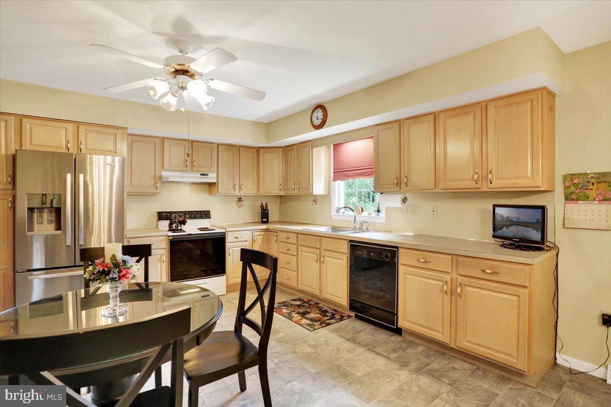 12 Archer Lane Reading, PA 19607 - Photo 22 of 39 a kitchen with a refrigerator a stove cabinets and a dining table