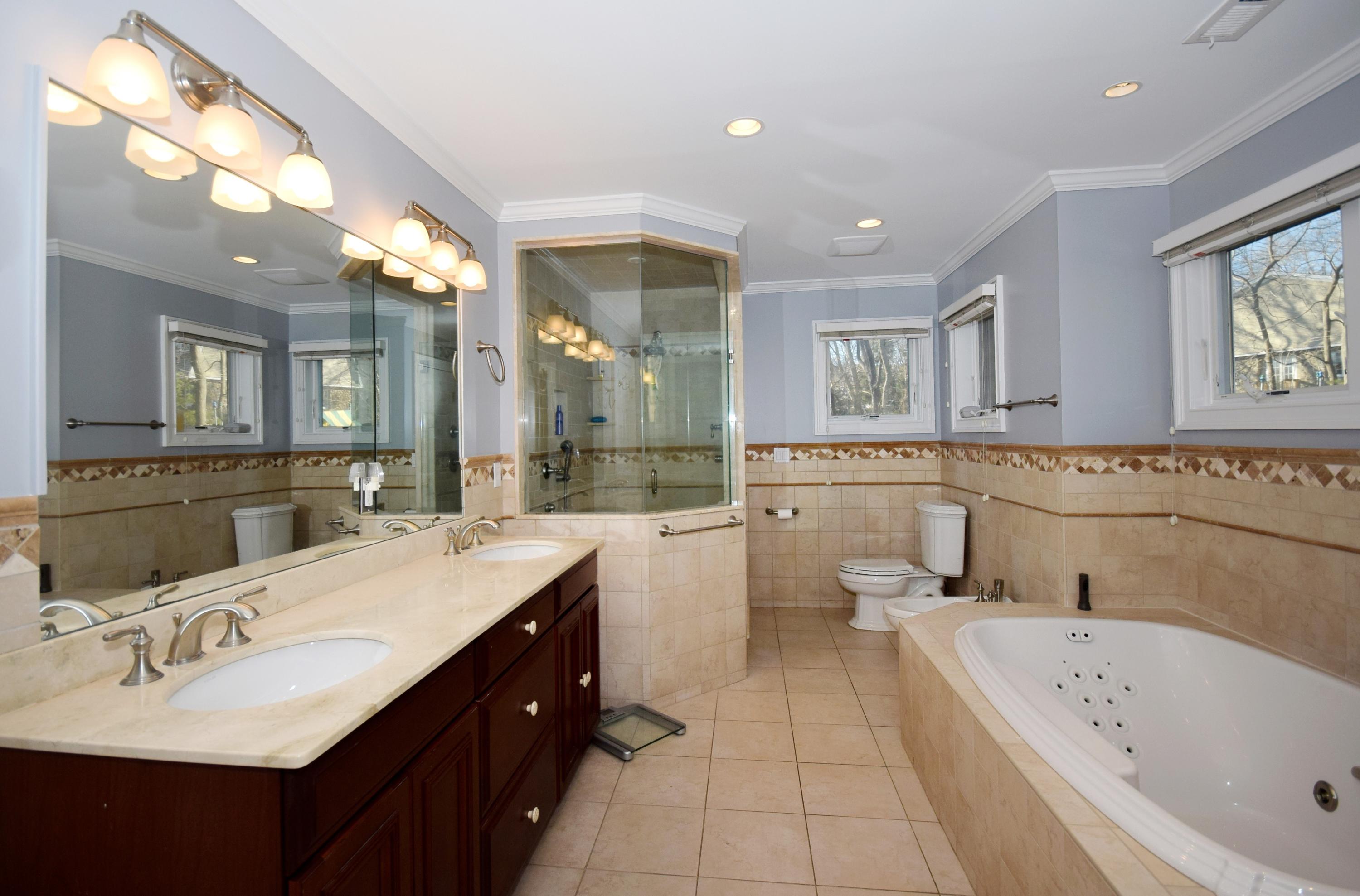 6 Wilson Ridge Road East Darien, CT 06820 - Photo 16 of 25 a bathroom with a bathtub a double vanity sink and mirror