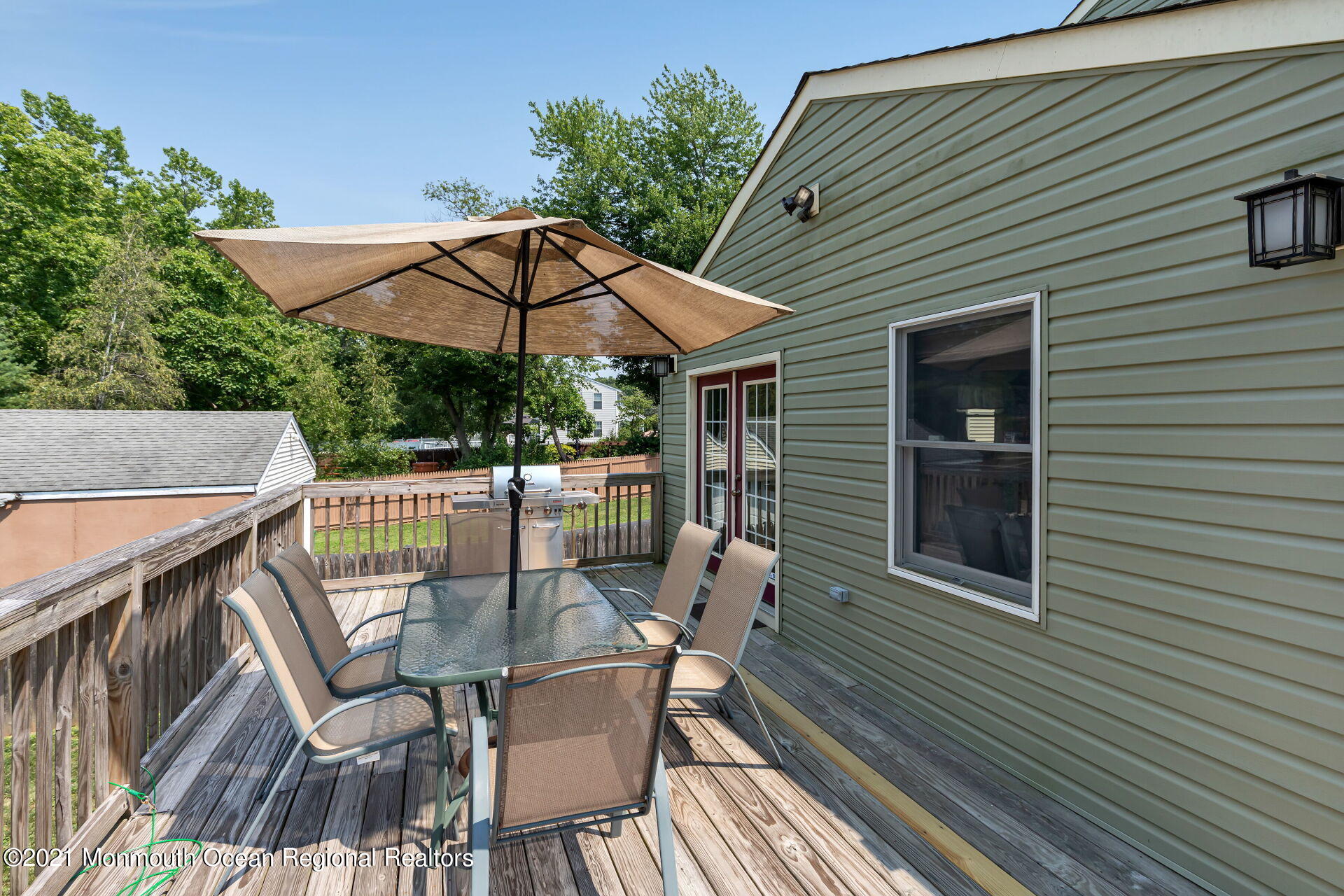 107 Aberdeen Road Aberdeen, NJ 07747 - Photo 31 of 32 a view of a patio with table and chairs under an umbrella with wooden floor