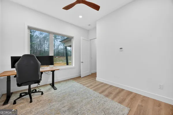 a view of a workspace with furniture and a window