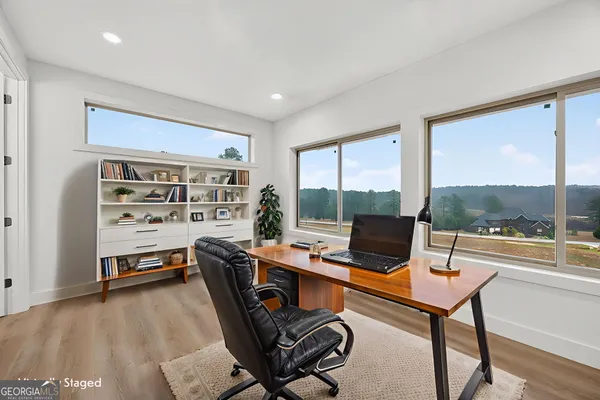 a view of a workspace with furniture and a window