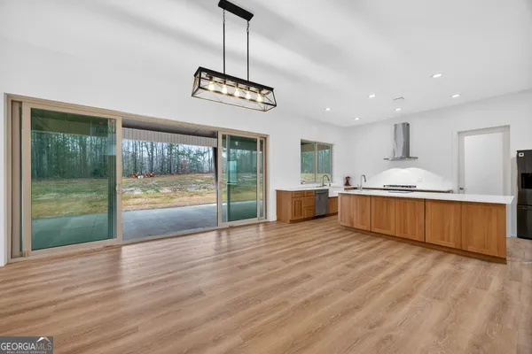 a view of kitchen with granite countertop stainless steel appliances and wooden floor