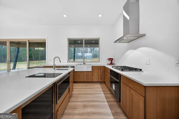 outdoor kitchen with stainless steel appliances granite countertop a stove a sink and a refrigerator