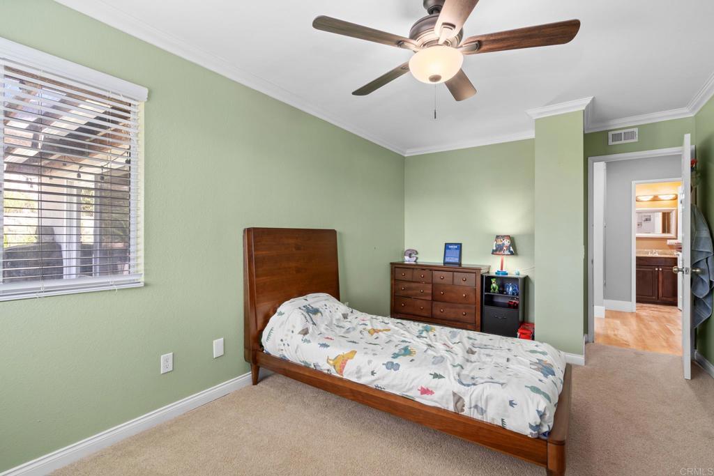 13439 Orange Blossom Lane Poway, CA 92064 - Photo 13 of 36 a bedroom with a bed and a chandelier