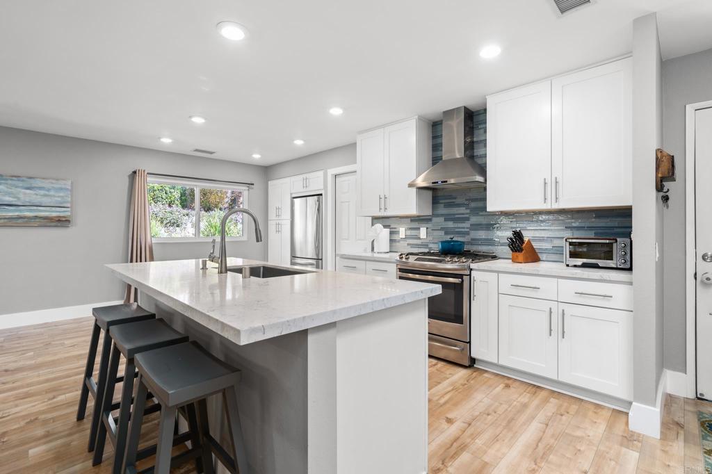 13439 Orange Blossom Lane Poway, CA 92064 - Photo 4 of 36 a kitchen with stainless steel appliances kitchen island granite countertop a sink and cabinets