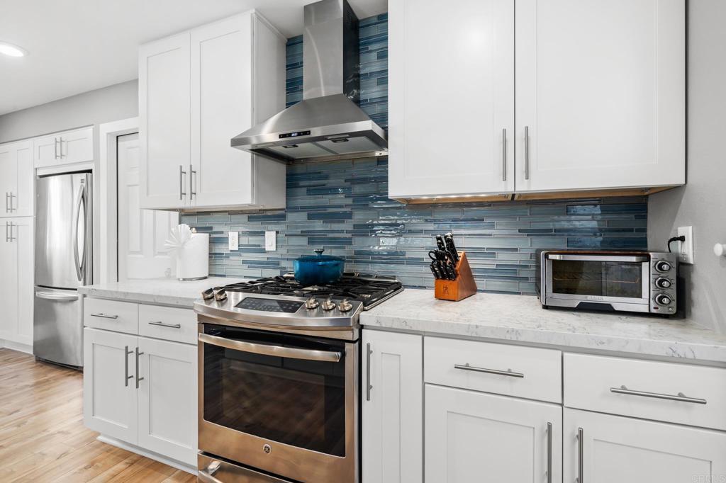 13439 Orange Blossom Lane Poway, CA 92064 - Photo 5 of 36 a kitchen with stainless steel appliances granite countertop grey cabinets a stove a sink and dishwasher