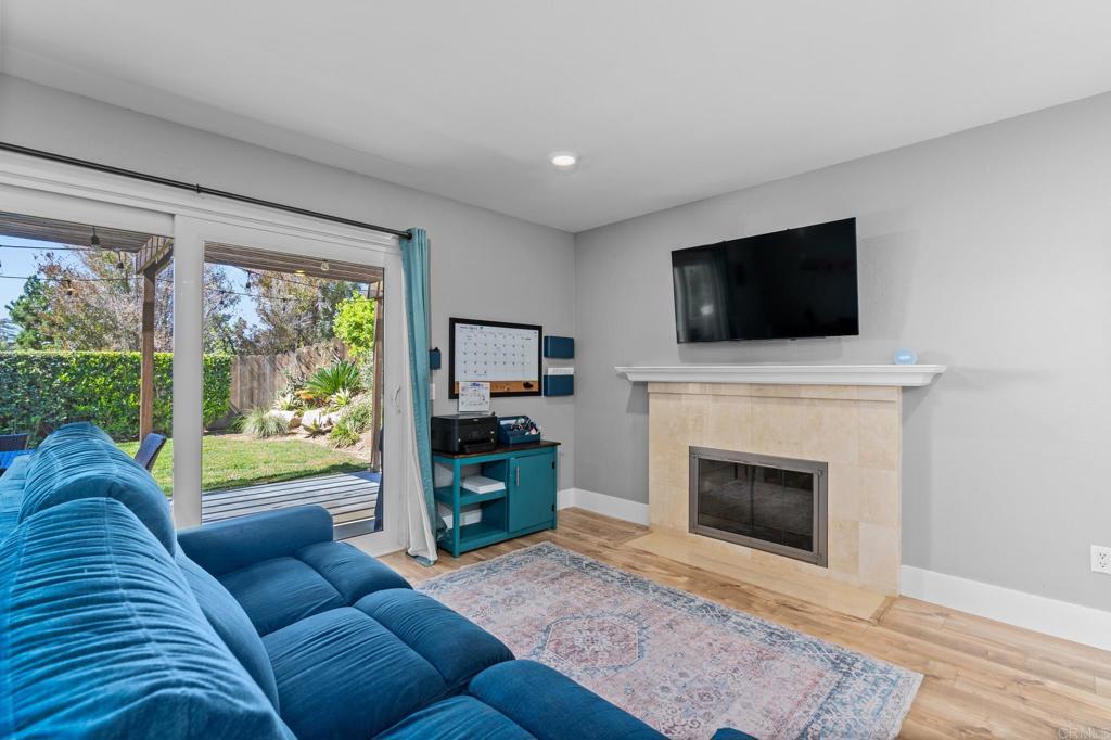 13439 Orange Blossom Lane Poway, CA 92064 - Photo 9 of 36 a living room with furniture a fireplace and a flat screen tv