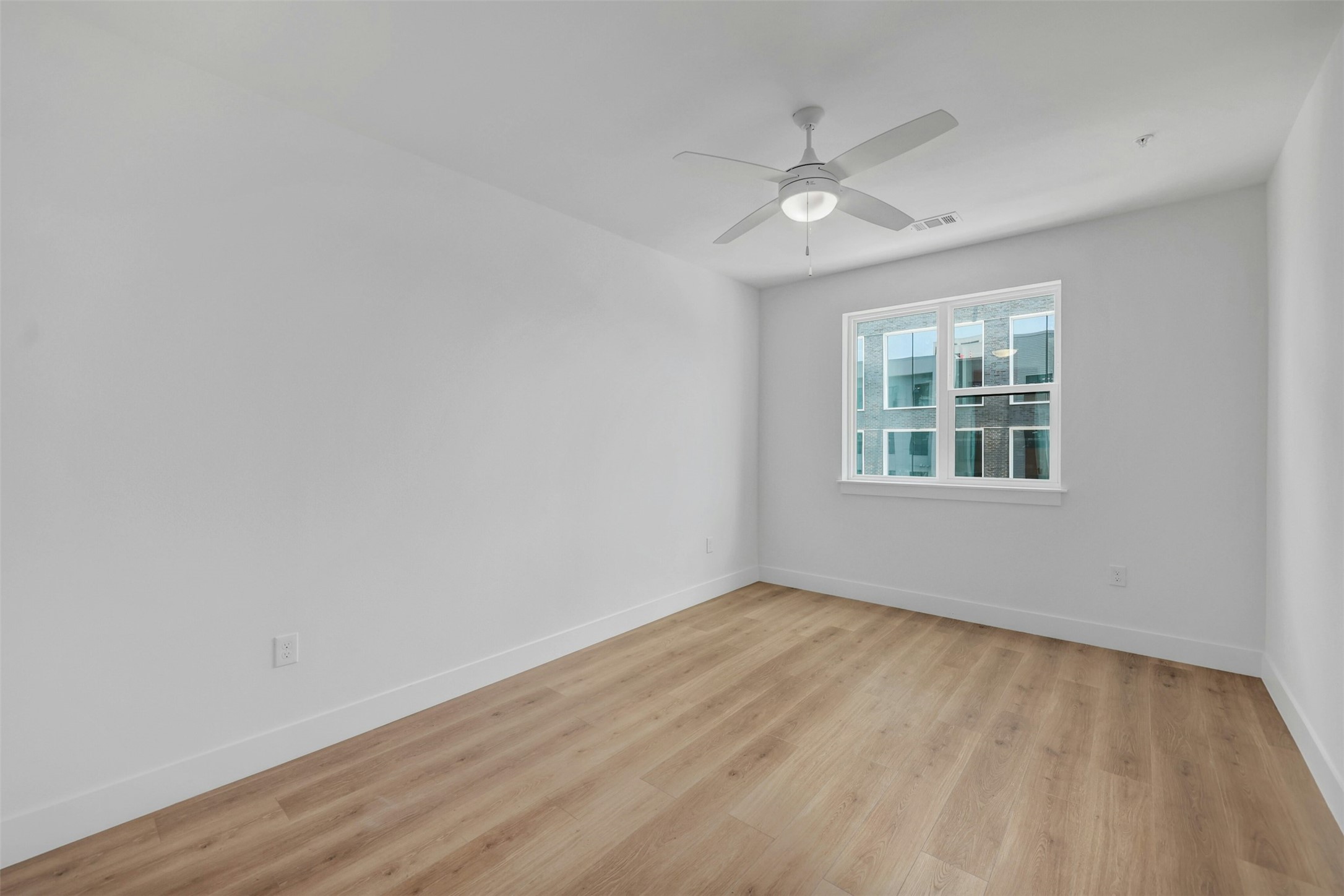 1701 Simond Avenue, Unit 411 Austin, TX 78723 - Photo 11 of 34 Unfurnished room featuring light wood finished floors and a ceiling fan