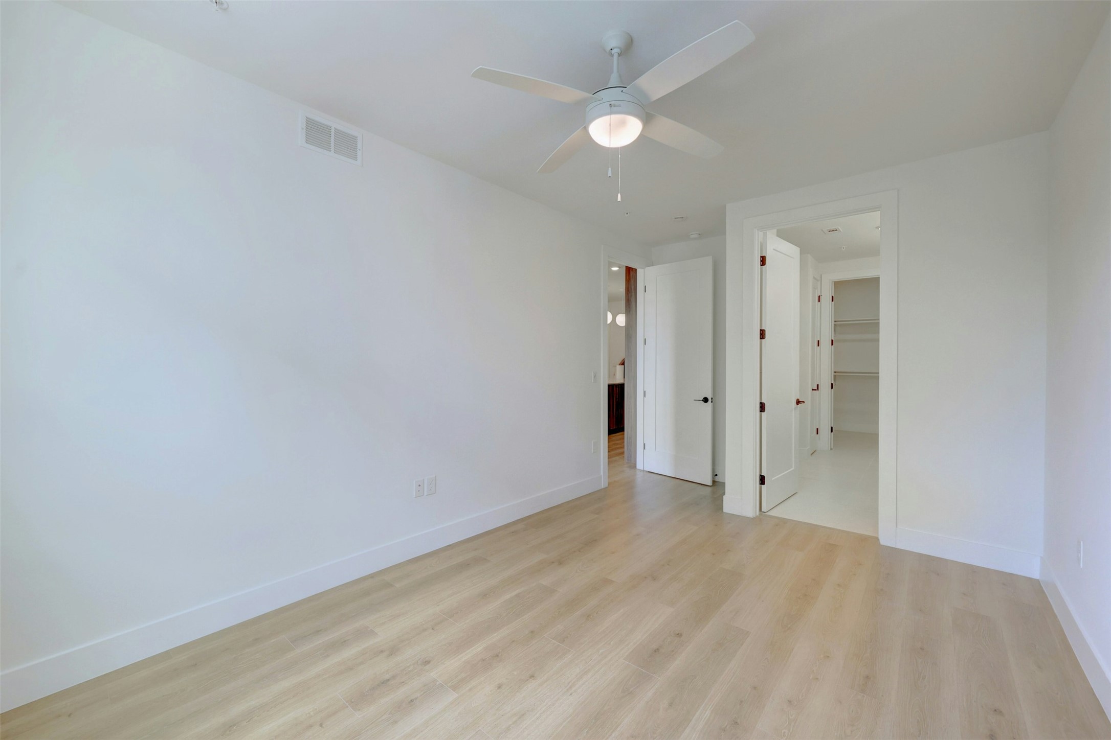 1701 Simond Avenue, Unit 411 Austin, TX 78723 - Photo 12 of 34 Empty room with light wood-style floors and a ceiling fan