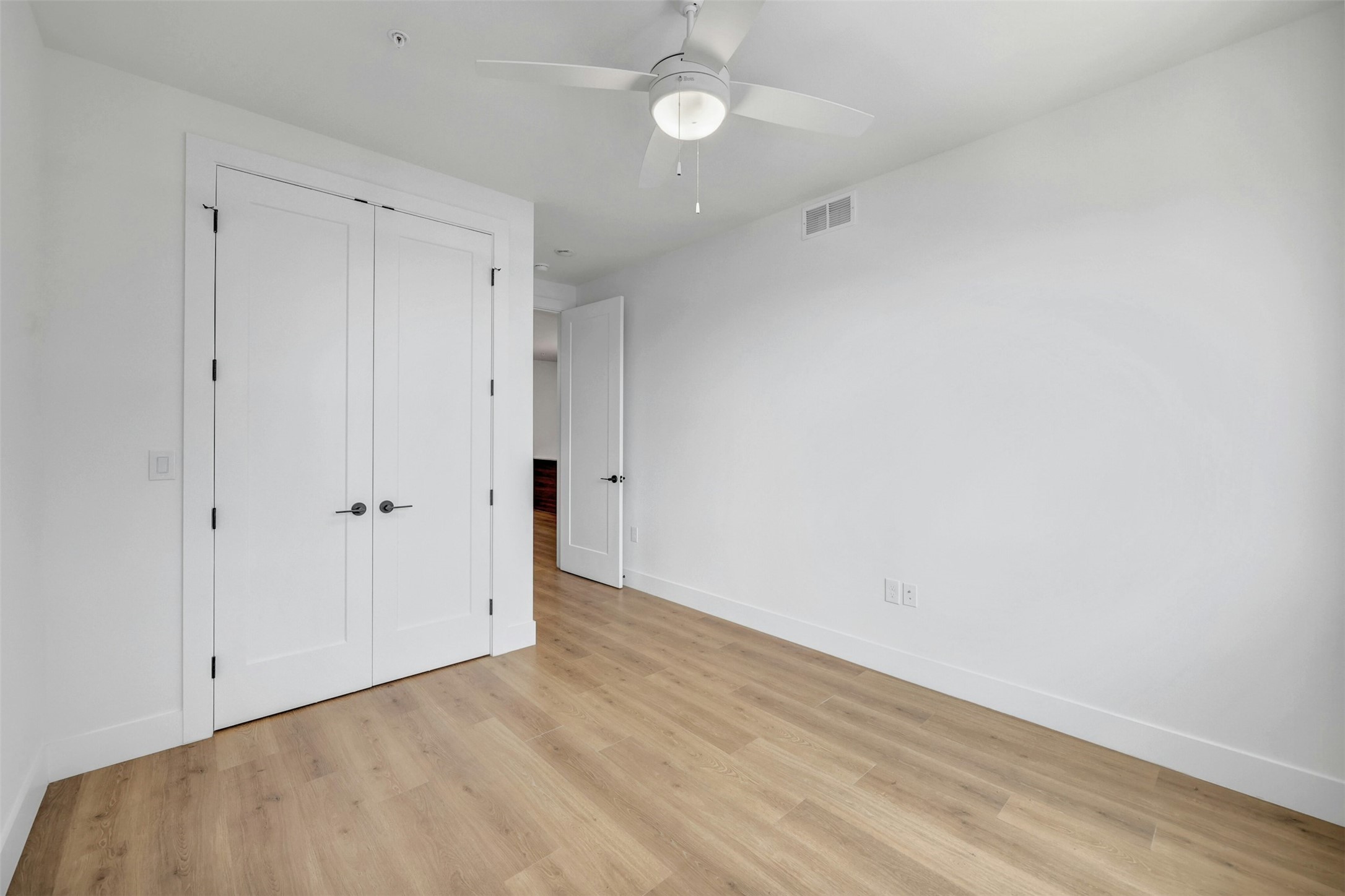 1701 Simond Avenue, Unit 411 Austin, TX 78723 - Photo 17 of 34 Unfurnished bedroom featuring light wood-style floors, a closet, and ceiling fan