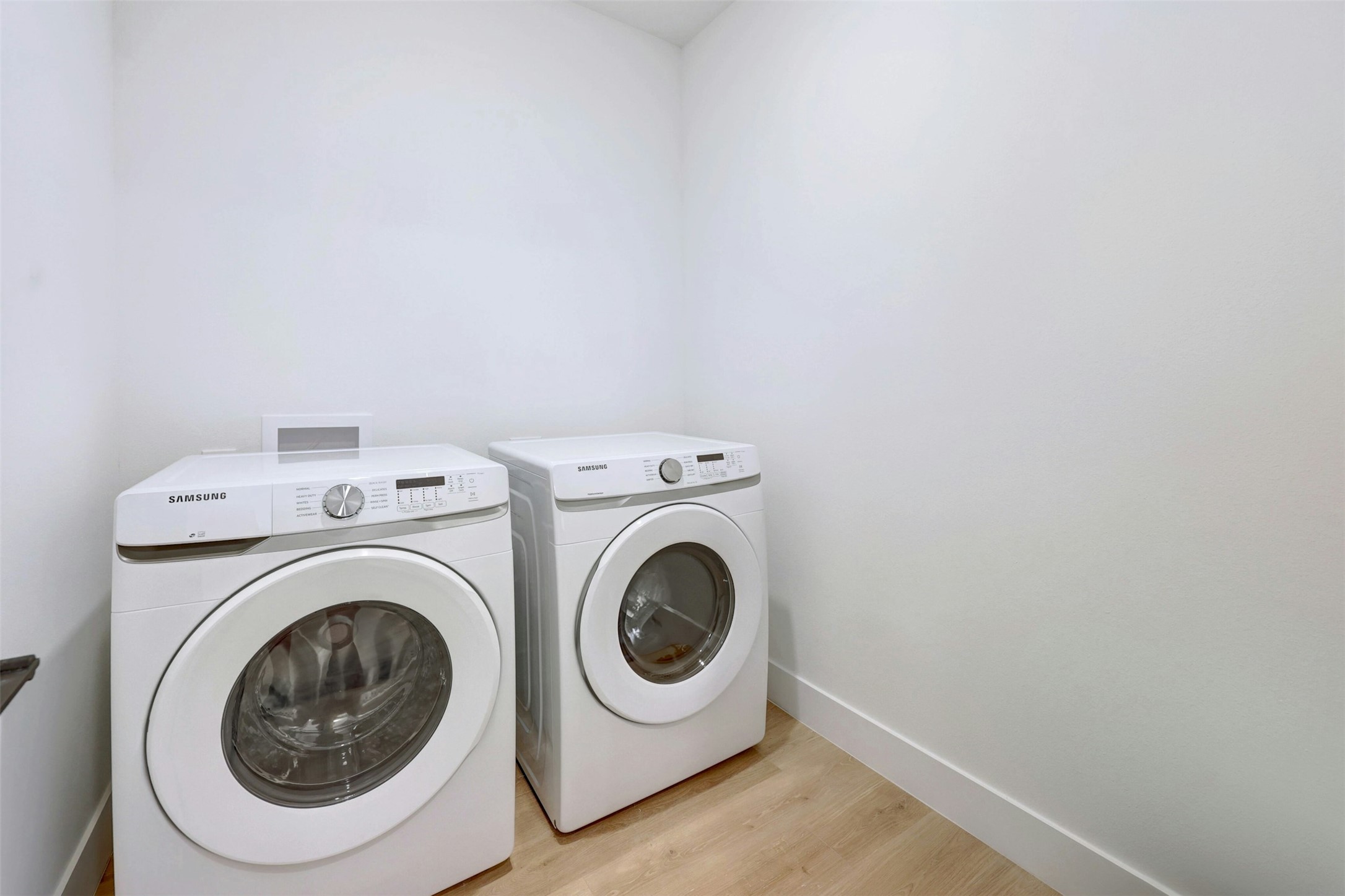 1701 Simond Avenue, Unit 411 Austin, TX 78723 - Photo 20 of 34 Laundry area featuring washing machine and clothes dryer and light wood-style flooring