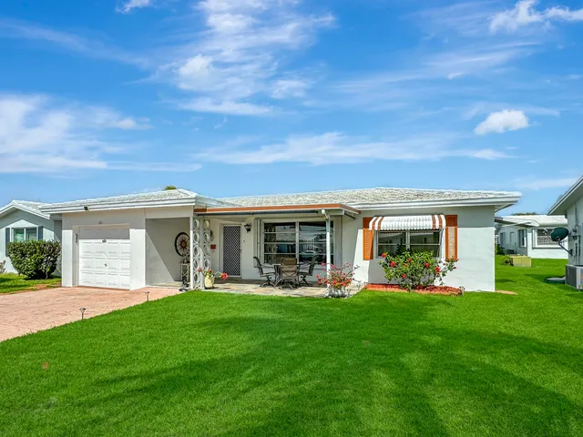 a front view of house with a garden and trees