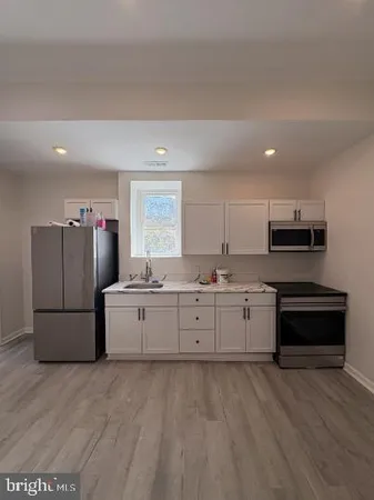 a kitchen with cabinets and wooden floor