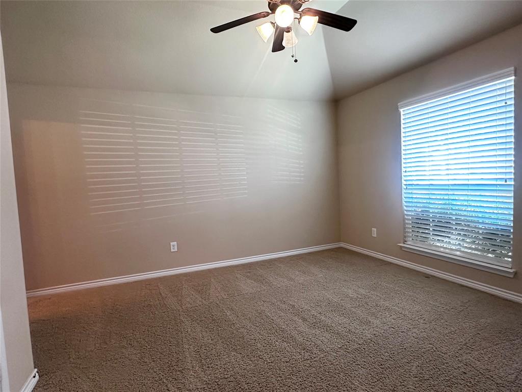 12135 Jasmine Lane Frisco, TX 75035 - Photo 21 of 31 an empty room with a chandelier fan and windows