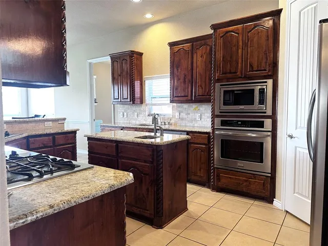 a kitchen with granite countertop a stove and a sink