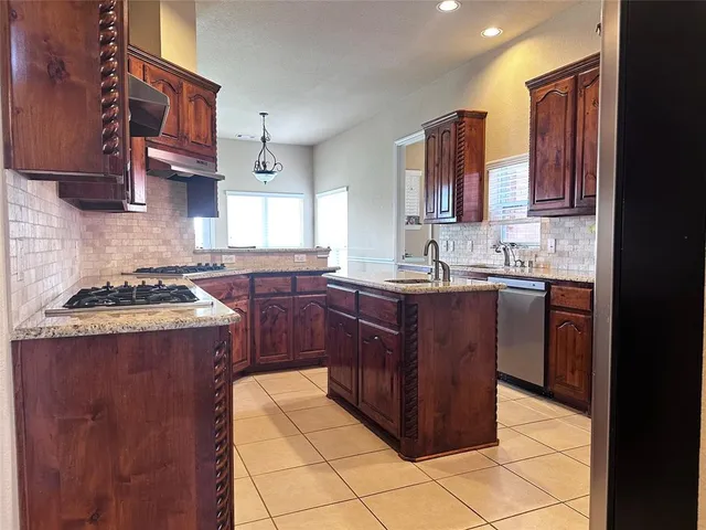 a kitchen with a sink a stove and cabinets