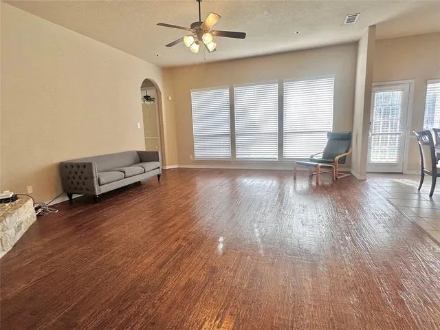 a view of a room with wooden floor and a ceiling fan