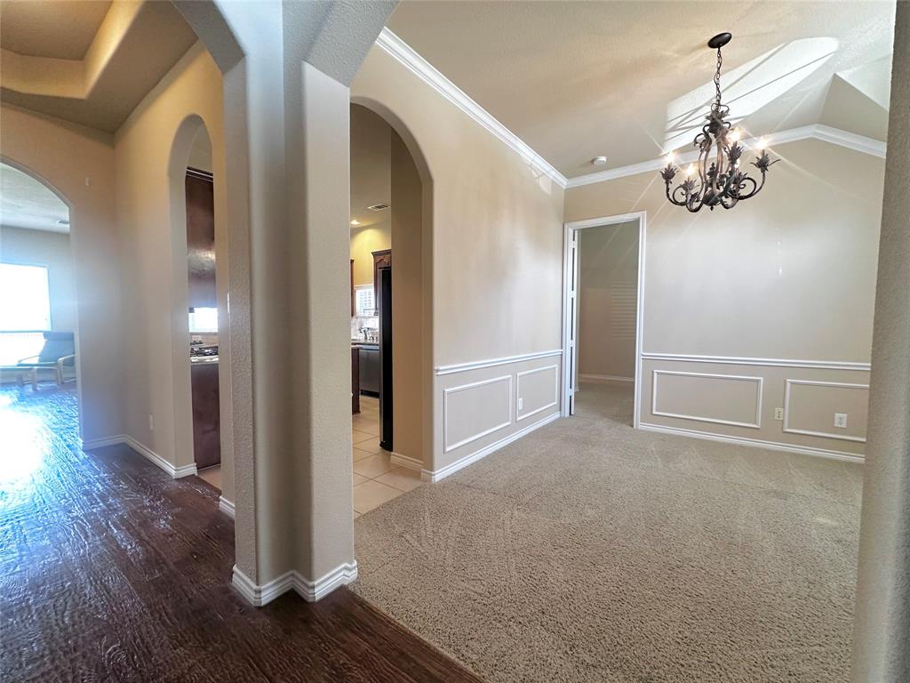 12135 Jasmine Lane Frisco, TX 75035 - Photo 10 of 31 a view of a hallway with wooden floor and chandelier