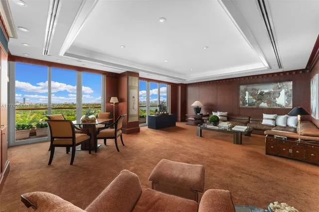 a living room with furniture a fireplace and a large window