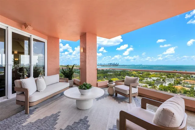 a living room with patio furniture and a potted plant